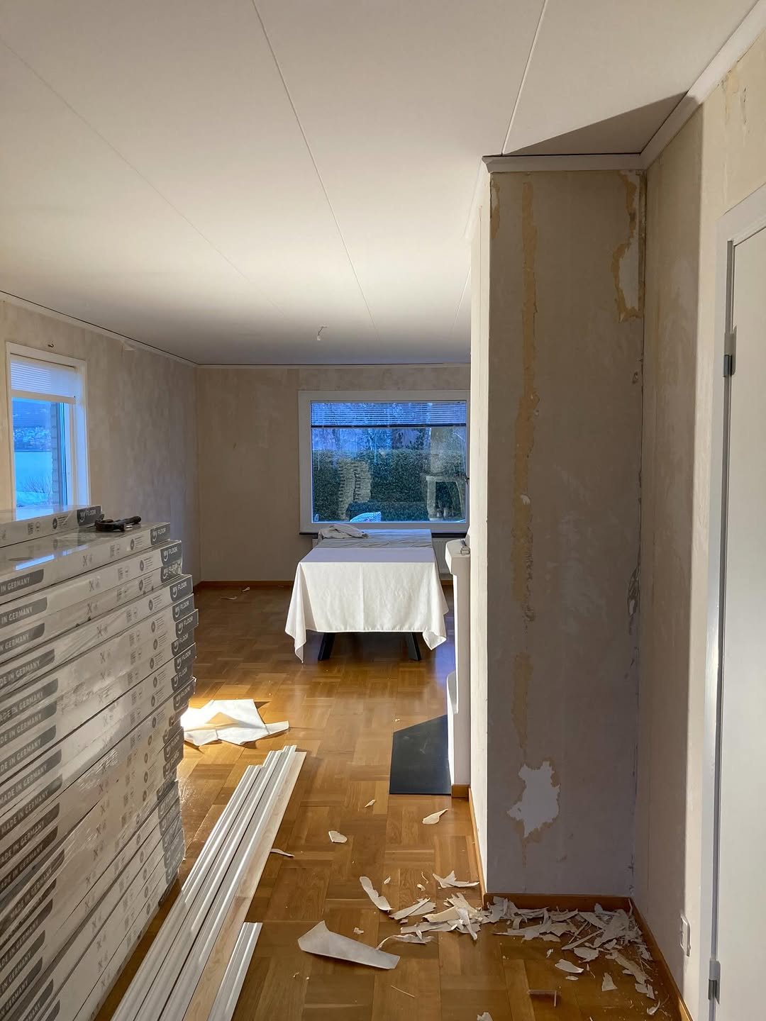 Vardagsrum där de gamla tapeterna har rivits ner