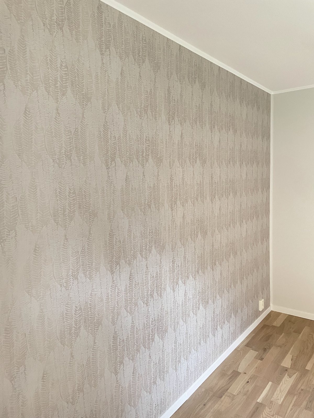 Vägg med nyuppsatt mönstrad tapet